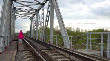 Küçük güzel kız demiryolu Köprüsü kırsal boyunca yürüyüş.