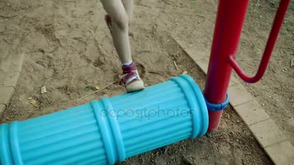 Pequena menina bonita envolvida em aparelhos de treinamento esportivo no parque da cidade de verão . — Vídeo de Stock