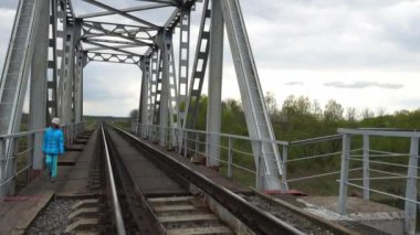 Küçük güzel kız demiryolu Köprüsü kırsal boyunca yürüyüş.