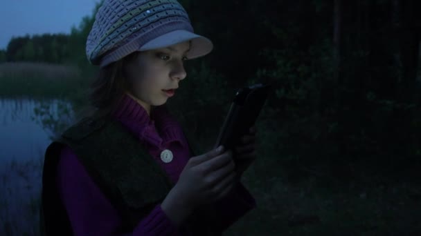 Kleines schönes Mädchen liest auf Tablet — Stockvideo