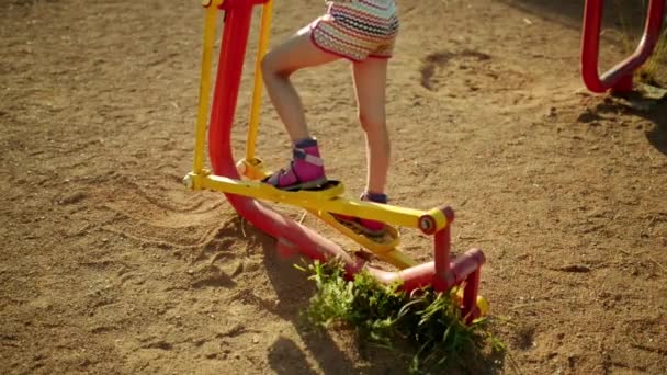 Pequena menina bonita envolvida em aparelhos de treinamento esportivo no parque da cidade de verão . — Vídeo de Stock
