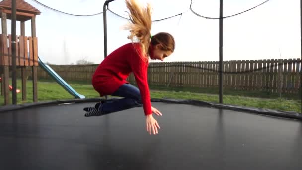 Piccola bella ragazza che salta sul trampolino in un parco autunnale . — Video Stock