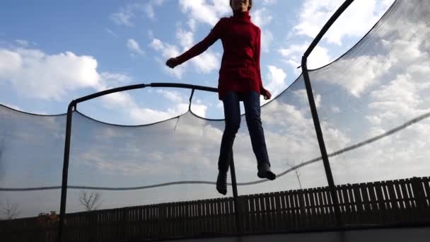 Trochę piękna dziewczyna, skoki na trampolinie w jesienny park. — Wideo stockowe