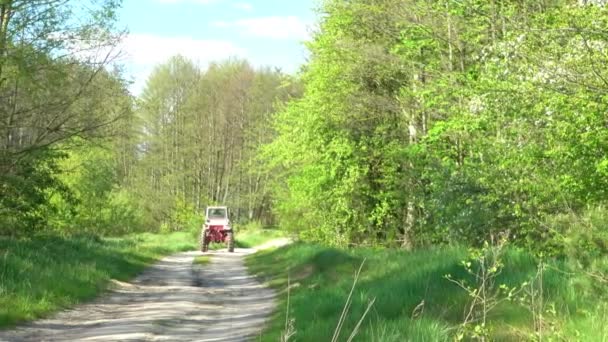 Liten brun traktor kör längs vägen på landsbygden. — Stockvideo