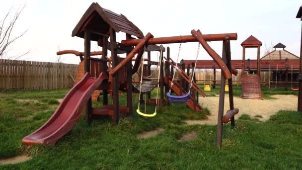 Children's playground with swings in autumn city park. — Stock Video