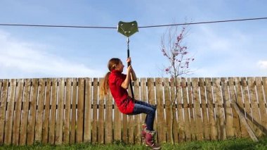 Küçük güzel kız zipline biniyor. Zipline veya tramvay karabina veya blok, hangi, belirli açıyla gerilmiş ip insanlar yerçekimi altında hareket.