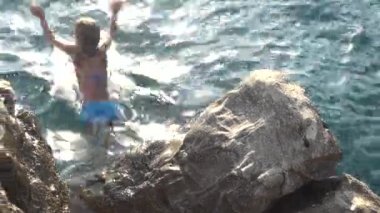 Küçük güzel kız taştan Hırvatistan Adriyatik sahil üzerinde denize atlama.