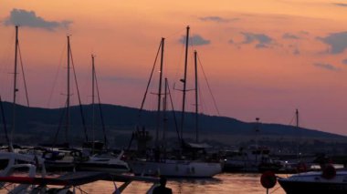 Akşam marina port Sozopol, Bulgaristan. Yatlar ve günbatımı fonunda gemi.