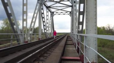 Küçük güzel kız demiryolu Köprüsü kırsal boyunca yürüyüş.