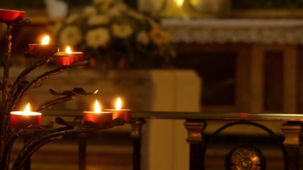 Ceremonial candles in Catholic church burn on metal stands — Stock Video