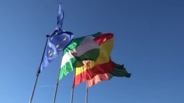 Avrupa Birliği, İspanya, Andalusia ve Granada bayrakları mavi gökyüzü karşı dönmeye başladı..