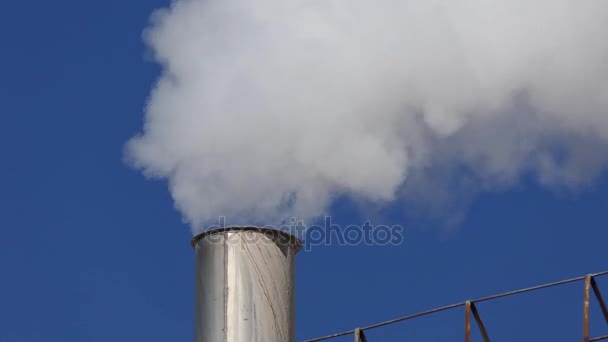 White smoke swirls from factory metal pipe on blue sky background — Stock Video