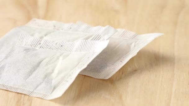 Paper bags with tea spinning on wooden cutting board — Stock Video