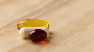 Beyaz, sarı, kırmızı tıbbi kapsül spin ahşap masa