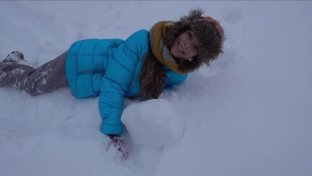 Όμορφο κοριτσάκι που παίζει στο χιόνι στο ξέφωτο μεγάλο χειμώνα — Αρχείο Βίντεο