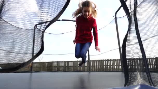 Trochę piękna dziewczyna, skoki na trampolinie w jesienny park. — Wideo stockowe