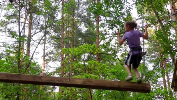 Petite fille dans le parc d'aventure. Parc d'aventure est un endroit qui peut contenir une grande variété d'éléments, tels que des exercices d'escalade de corde, parcours d'obstacles et tyroliennes. Ils sont destinés aux loisirs .