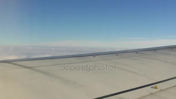 Asa de um avião voando sobre nuvens brancas fofas em alta altitude — Vídeo de Stock