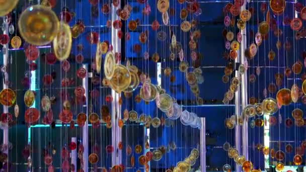 I cerchi multicolori di vetro sono sospesi su corde sotto forma di un ornamento . — Video Stock