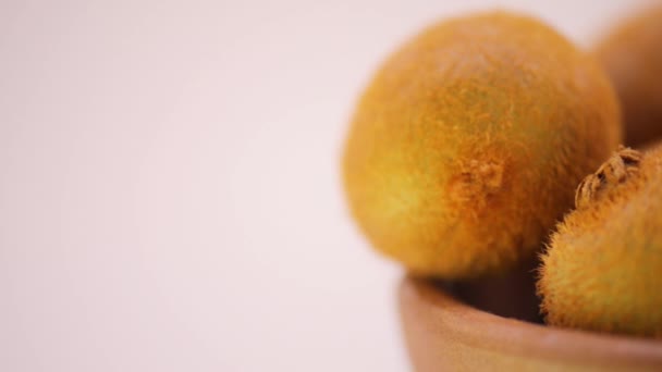 Circular motion: several ripe kiwi in a plate on a bright background. — Stock Video
