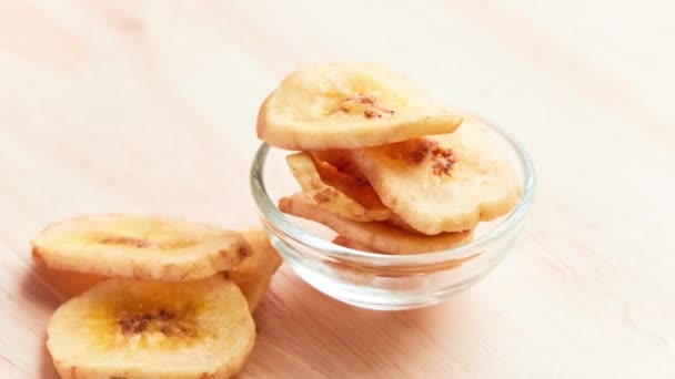 Banane secche vorticano sul tavolo di legno . — Video Stock