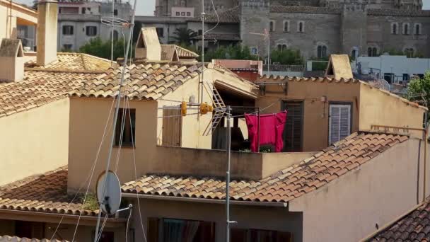 Gewaschene Kleidung wird in einem schönen Haus in einer kleinen Stadt im Wind getrocknet. — Stockvideo