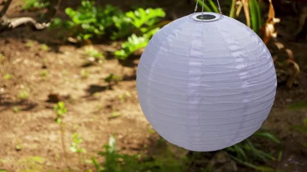 Lámpara en forma de bola de tejido en baterías solares en el jardín . — Vídeos de Stock