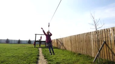 Küçük güzel kız zipline biniyor. Zipline veya tramvay karabina veya blok, hangi, belirli açıyla gerilmiş ip insanlar yerçekimi altında hareket.