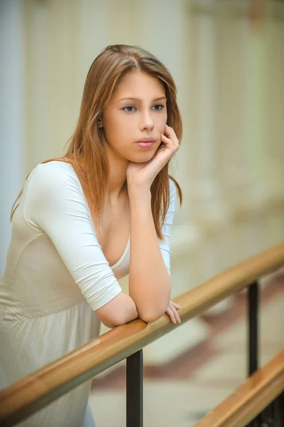 Mulher bonita nova com cabelo longo perto de corrimão de madeira . — Fotografia de Stock