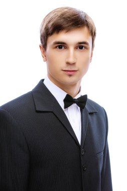 Siyah takım elbiseli genç adam, beyaz gömlek ve kravat kelebeği.