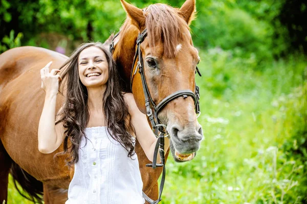 Vrouw Witte Jurk Houdt Bruin Paard Tegen Achtergrond Van Zomer — Stockfoto