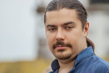 Güzel, koyu renk saçlı bir adamın portresi..