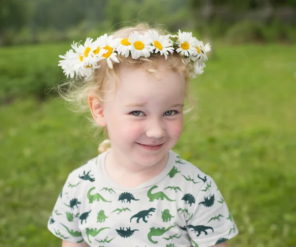 Mignonne petite fille souriante dans la couronne de camomille — Photo