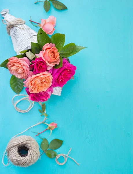 Verse roze en Oranje Rozen in papieren omslag tegenover blauwe achtergrond — Stockfoto