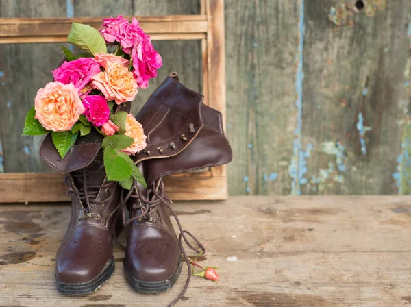 Rosas rosadas y naranjas frescas en botas marrones vintage —  Fotos de Stock