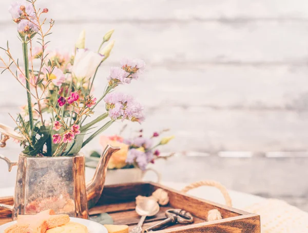 Mooie bloemen in oude vintage theepot op mooie houten tra — Stockfoto