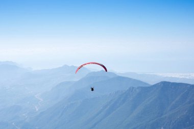 Türkiye 'nin Antalya ilinin Türk Rivierası' ndaki bir sahil beldesi olan Kemer yakınlarındaki dağların üzerinden uçan Paraglider