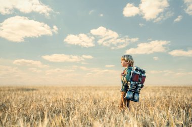 Sırt çantası olan küçük bir çocuk.