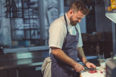 Adam mutfakta yemek pişiriyor.