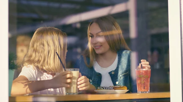 Smiling mother and daughter having breakfast — Stock Photo, Image