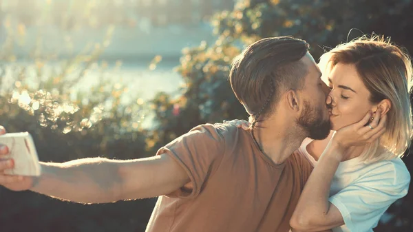 Kissing young couple making selfie — Stock Photo, Image