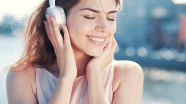 Genç kız gülümseyerek müzik açık havada için dinle