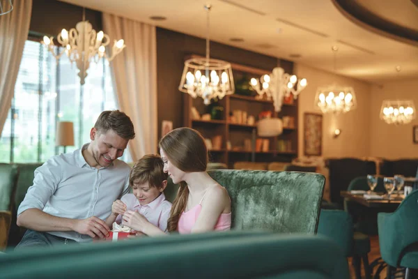 Young family with a gift in a restaurant