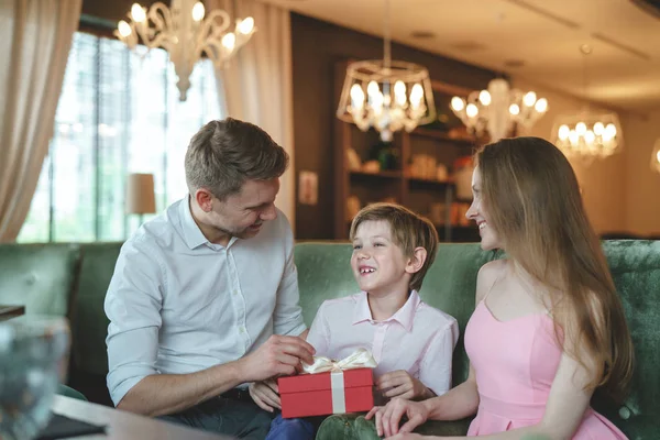 Happy family with a gift in a restaurant