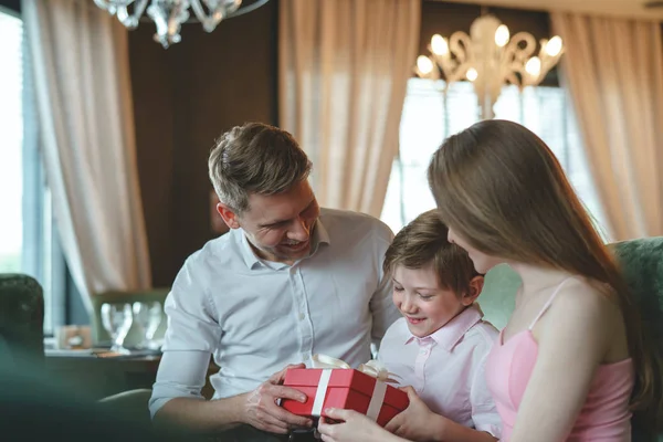 微笑的家庭与礼物在餐馆 — 图库照片