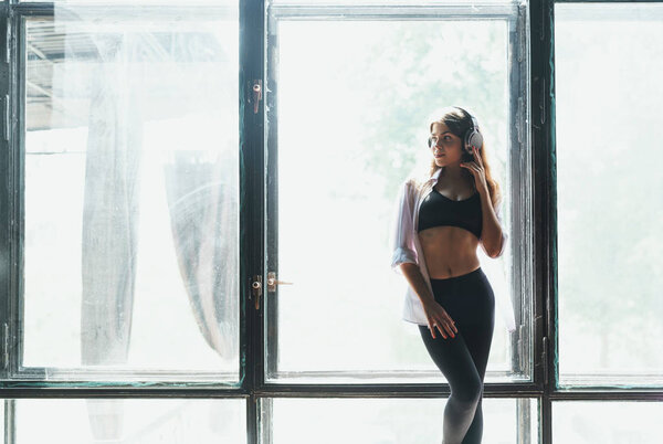 Young attractive woman by the window in the loft