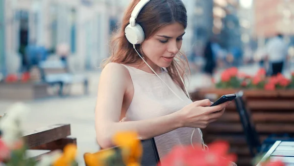 Lächelndes Junges Mädchen Hört Musik Über Kopfhörer Auf Der Bank — Stockfoto