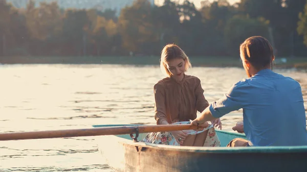 Молодая пара в лодке на закате — стоковое фото