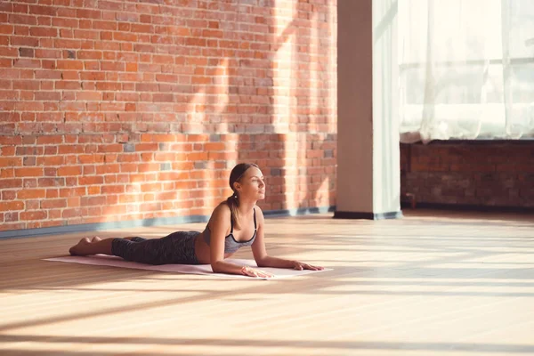 Young instructor doing yoga in the loft — Stock Photo, Image