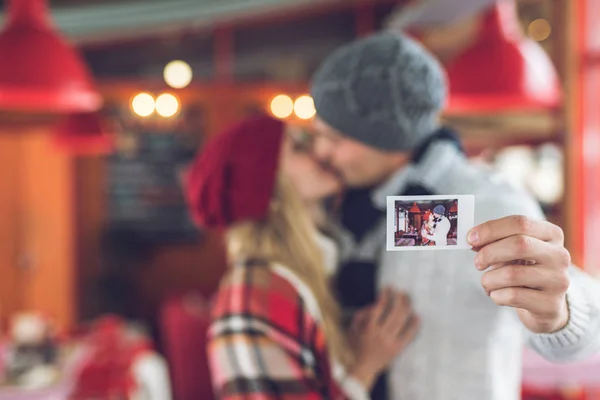 Beijar o jovem casal com uma foto — Fotografia de Stock